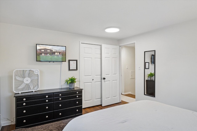 bedroom with dark wood-type flooring and a closet