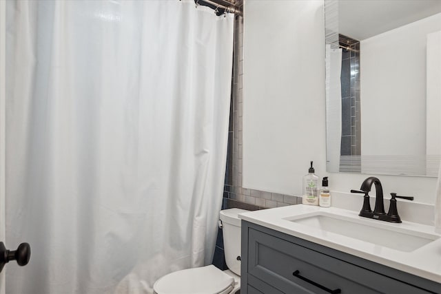 bathroom featuring toilet, vanity, and a shower with curtain