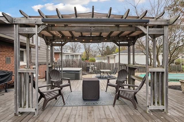 deck with a hot tub and a fenced backyard