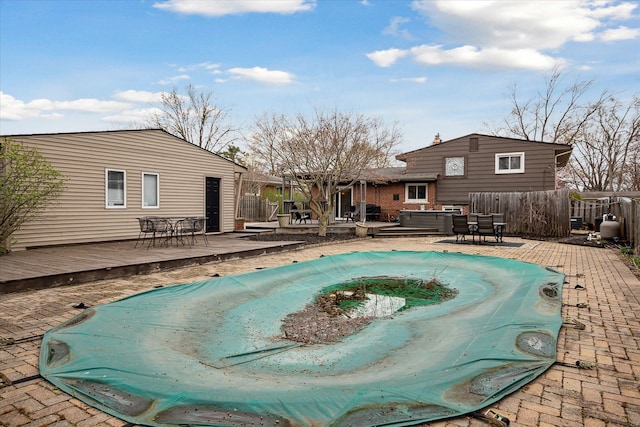 view of swimming pool featuring a wooden deck, a fenced in pool, and outdoor dining space