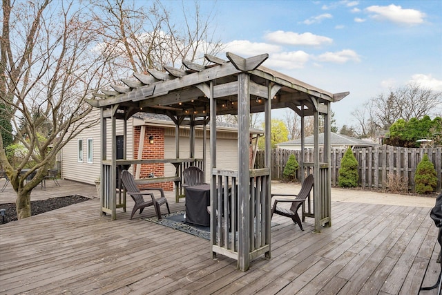 wooden deck featuring fence and a pergola
