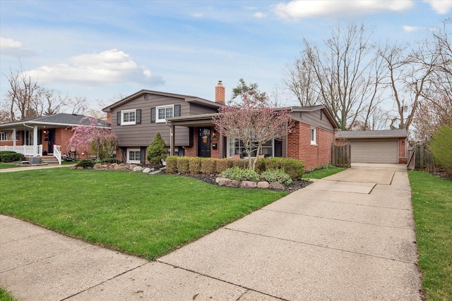 split level home featuring a front lawn, an outbuilding, a detached garage, a porch, and brick siding