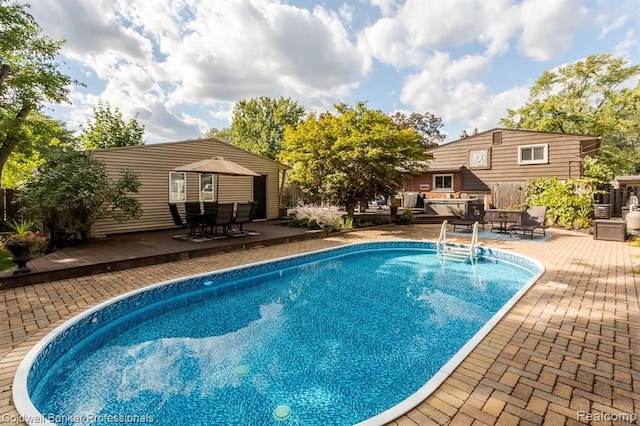 outdoor pool featuring outdoor dining space, a patio, and a deck
