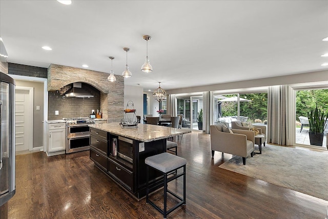 kitchen featuring backsplash, recessed lighting, appliances with stainless steel finishes, and a breakfast bar area