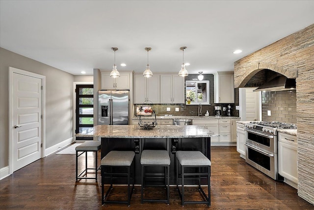 kitchen with backsplash, baseboards, a kitchen breakfast bar, and stainless steel appliances