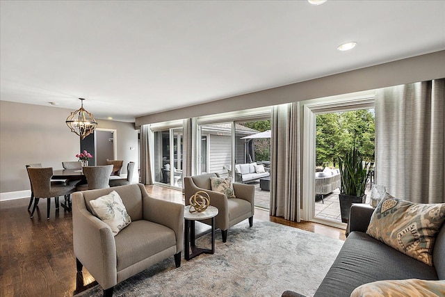 living area with recessed lighting, wood finished floors, baseboards, and a notable chandelier