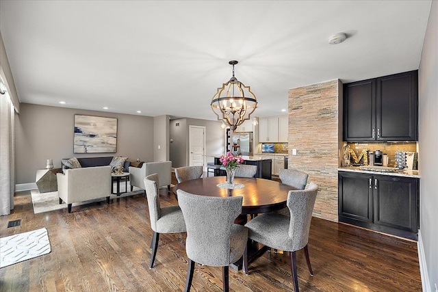 dining area with an inviting chandelier, dark wood-style floors, and recessed lighting