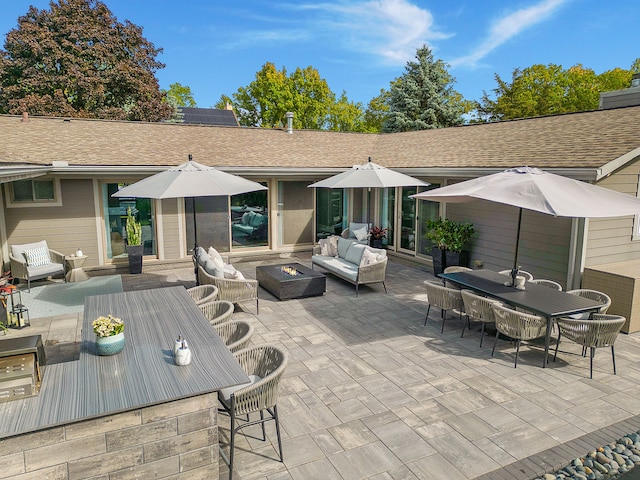view of patio / terrace featuring outdoor dining area, exterior bar, and an outdoor living space with a fire pit