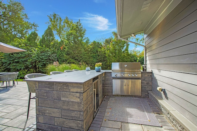 view of patio / terrace featuring an outdoor kitchen, outdoor dining area, a grill, and outdoor wet bar