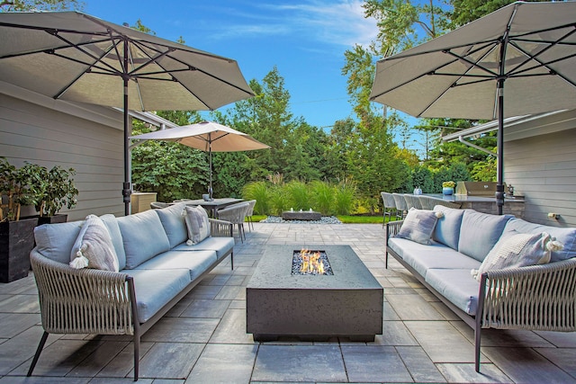 view of patio / terrace with an outdoor living space with a fire pit and outdoor dining space