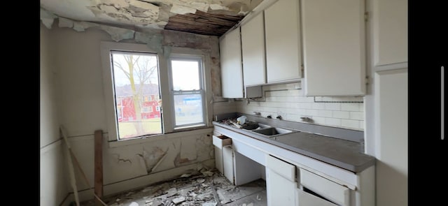 kitchen featuring white cabinetry and a sink