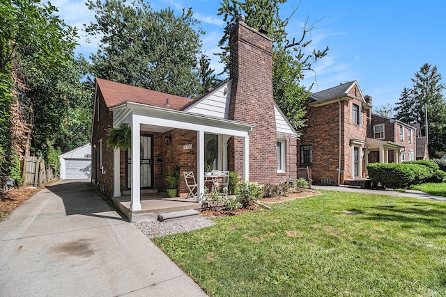 view of front of house featuring an outdoor structure, a porch, a front yard, a garage, and brick siding
