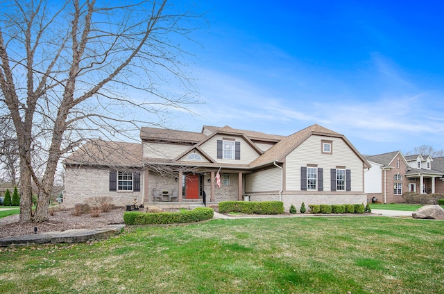 traditional home with a porch, a front lawn, and brick siding