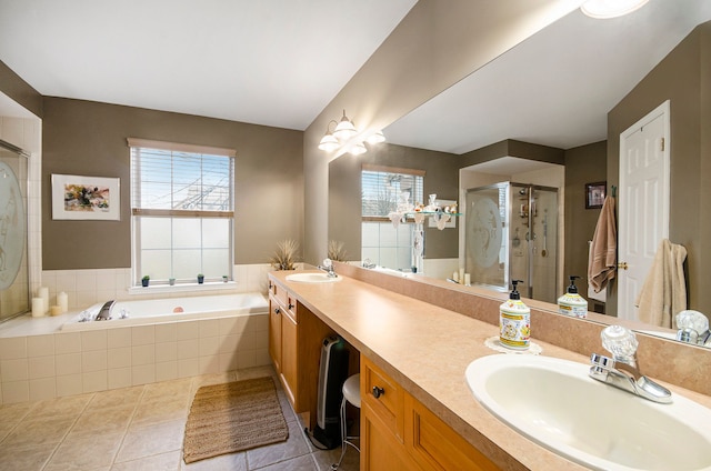 bathroom featuring plenty of natural light, a garden tub, a sink, and a stall shower