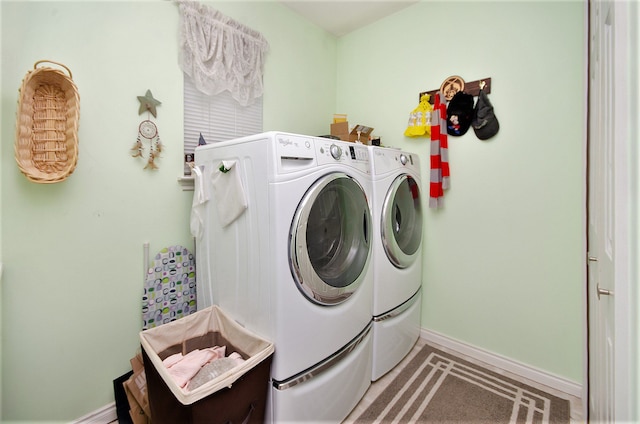 laundry area featuring baseboards, washer and dryer, and laundry area