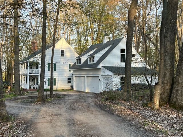 2457 Rocky Top Ln, Commerce Twp, MI 48382 - view of front of property with a chimney, dirt driveway, and a garage