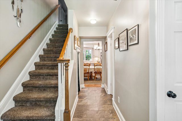 2457 Rocky Top Ln, Commerce Twp, MI 48382 - staircase with stone tile flooring, baseboards, and a chandelier
