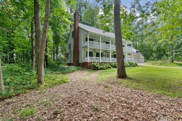 2457 Rocky Top Ln, Commerce Twp, MI 48382 - view of front of house featuring a chimney, a balcony, and a front yard