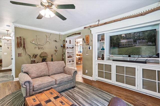 2457 Rocky Top Ln, Commerce Twp, MI 48382 - living room with a ceiling fan, crown molding, wood finished floors, and baseboards