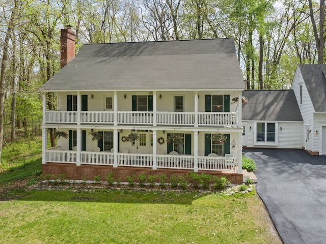 2457 Rocky Top Ln, Commerce Twp, MI 48382 - view of front of house with covered porch, a chimney, and a balcony