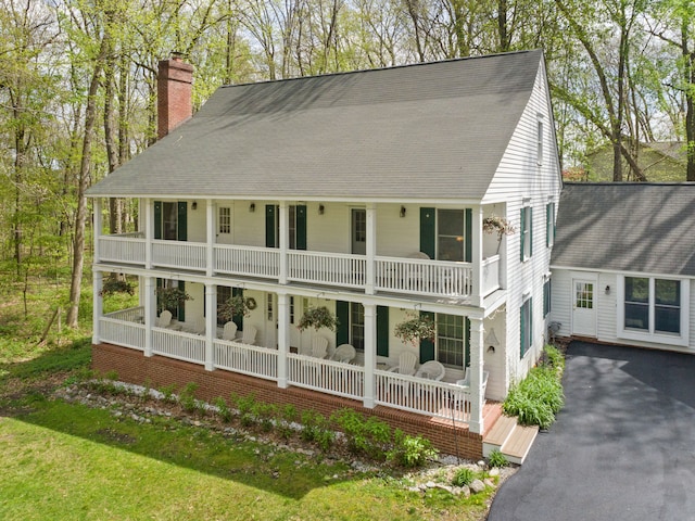 2457 Rocky Top Ln, Commerce Twp, MI 48382 - view of front of home with a porch, a chimney, a balcony, and roof with shingles