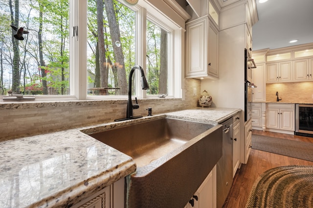 2457 Rocky Top Ln, Commerce Twp, MI 48382 - kitchen featuring wine cooler, tasteful backsplash, a sink, cream cabinets, and recessed lighting