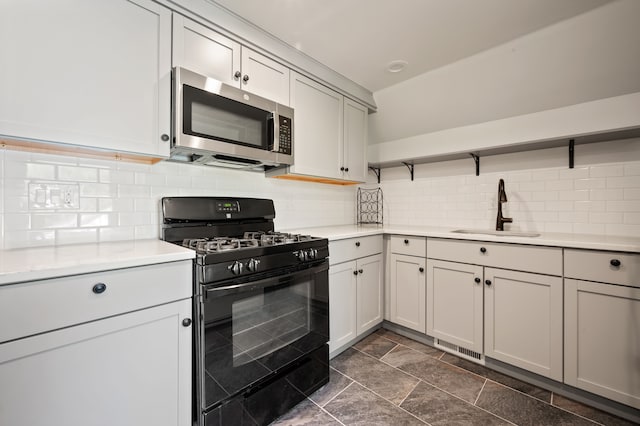 2457 Rocky Top Ln, Commerce Twp, MI 48382 - kitchen with stainless steel microwave, black range with gas stovetop, a sink, open shelves, and decorative backsplash