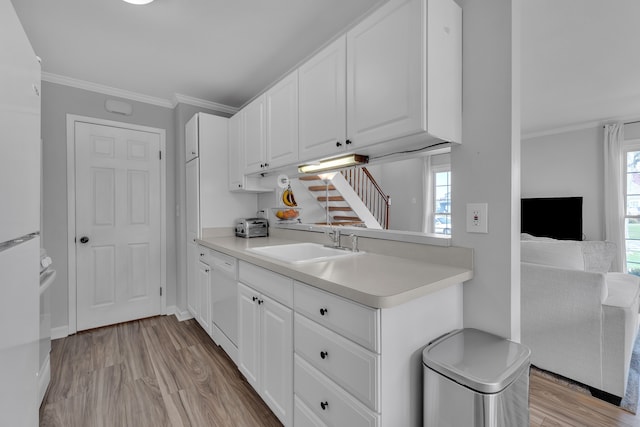 kitchen featuring light countertops, light wood-type flooring, and a sink