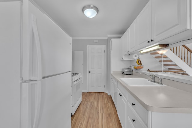 kitchen featuring light countertops, a sink, white appliances, light wood-type flooring, and crown molding