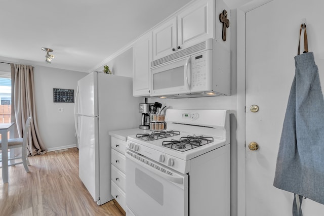 kitchen featuring white cabinets, light countertops, light wood-style flooring, and white appliances