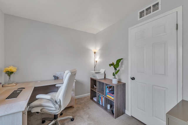 office area with visible vents, baseboards, and light carpet