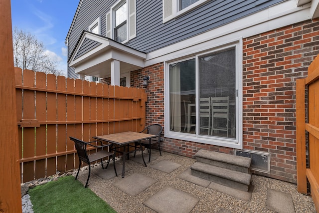 view of patio with outdoor dining area and fence