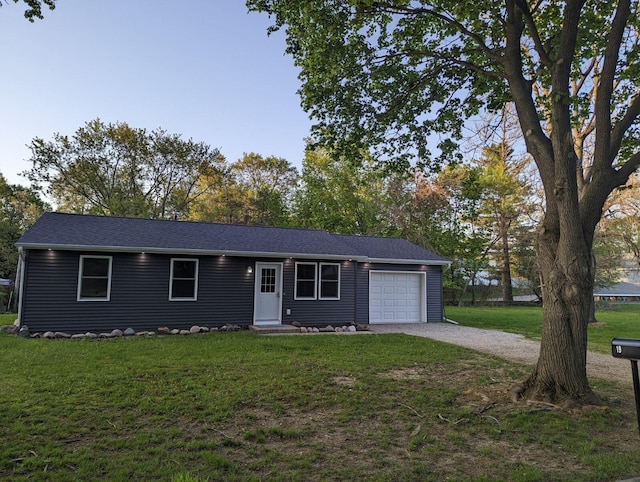 ranch-style house featuring a garage, driveway, and a front lawn