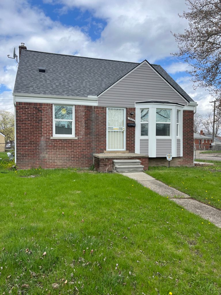 19659 Kelly Rd, Detroit, MI 48225 - view of front of property with brick siding, fence, a shingled roof, and a front yard