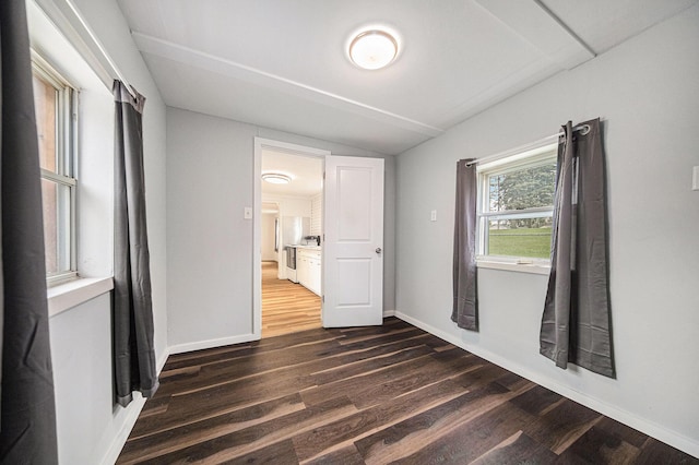 empty room with baseboards and dark wood-style floors