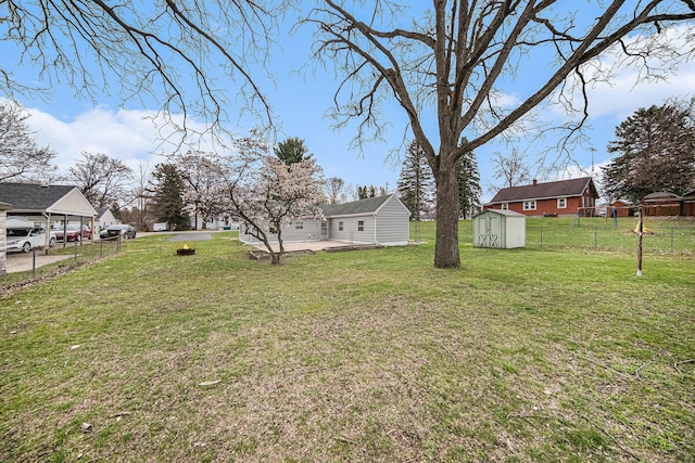 view of yard with fence, an outbuilding, and a storage shed