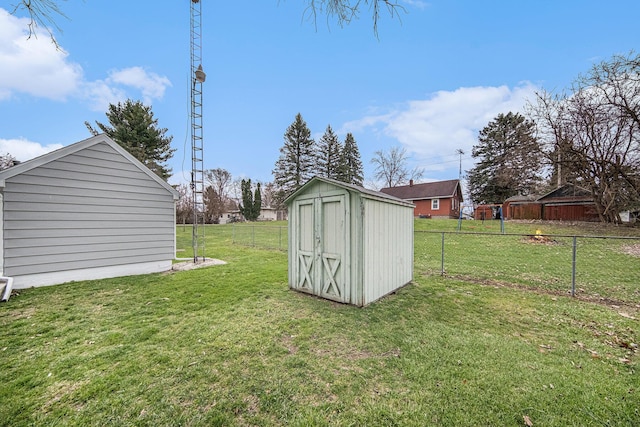 view of yard featuring fence, an outbuilding, and a shed