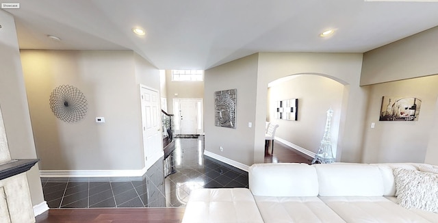 living room featuring baseboards, recessed lighting, arched walkways, and granite finish floor