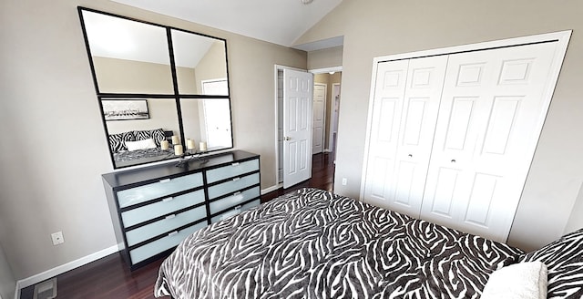 bedroom featuring dark wood finished floors, a closet, baseboards, visible vents, and lofted ceiling