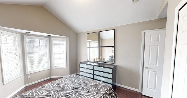 bedroom with dark wood-style floors, vaulted ceiling, and baseboards
