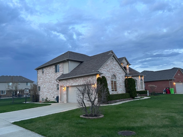 view of front of property featuring a front lawn, driveway, an attached garage, and fence