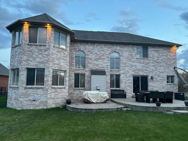 back of property featuring a yard, a patio, brick siding, and an outdoor hangout area