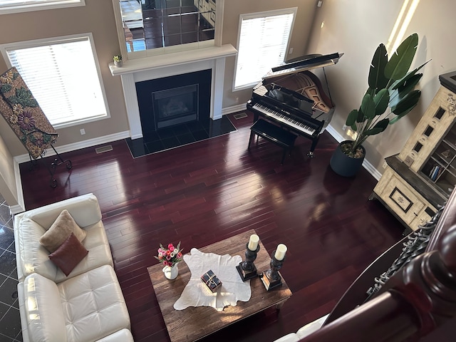 living area featuring a healthy amount of sunlight, hardwood / wood-style floors, and baseboards