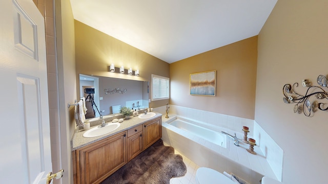 full bathroom with a bath, double vanity, a sink, and tile patterned floors