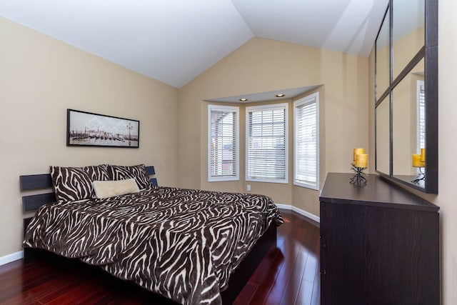 bedroom with lofted ceiling, wood finished floors, and baseboards