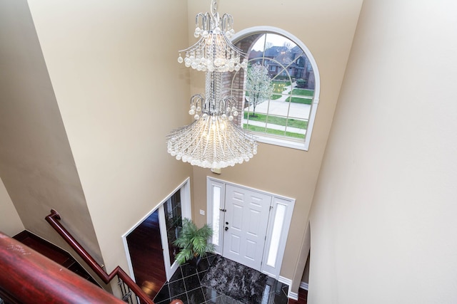 foyer with a high ceiling, an inviting chandelier, and a healthy amount of sunlight