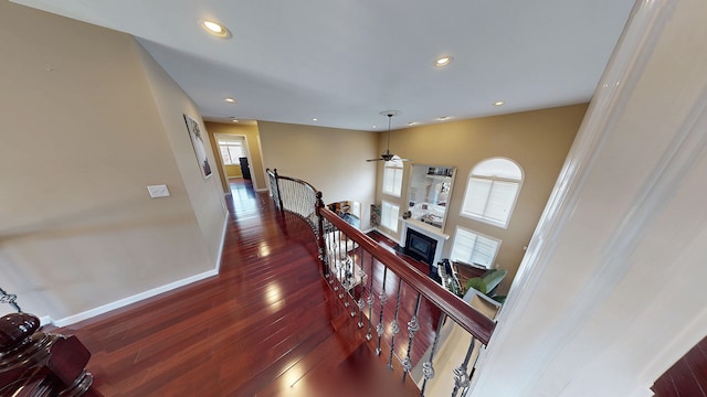 hallway with baseboards, recessed lighting, an upstairs landing, and dark wood-style flooring