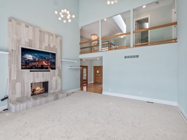 unfurnished living room with visible vents, carpet flooring, and a high ceiling