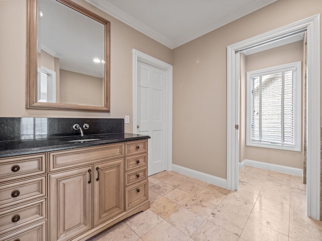 bathroom featuring baseboards, ornamental molding, and vanity