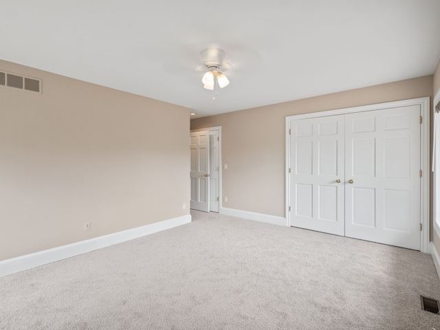 unfurnished bedroom featuring ceiling fan, visible vents, baseboards, and light carpet